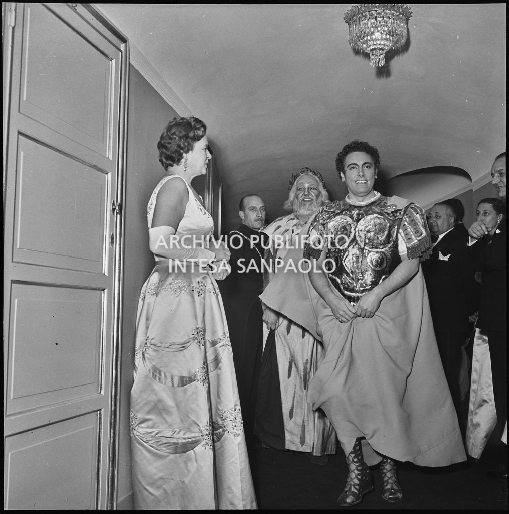 Il tenore Mario Del Monaco e il basso Nicola Zaccaria (in secondo piano), in abiti di scena, sfilano tra il pubblico del Teatro alla Scala al termine della rappresentazione dell'opera "Norma" di Vincenzo Bellini, diretta da Antonino Votto, con la regia di Margherita Wallmann, che inaugura la stagione lirica 1955-1956