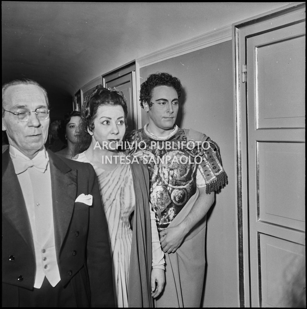 Da sinistra, il direttore d'orchestra Antonino Votto, il mezzosoprano Giulietta Simionato e il tenore Mario Del Monaco, in abiti di scena, al Teatro alla Scala, al termine della rappresentazione dell'opera "Norma" di Vincenzo Bellini, diretta da Antonino Votto, con la regia di Margherita Wallmann, che inaugura la stagione lirica 1955-1956