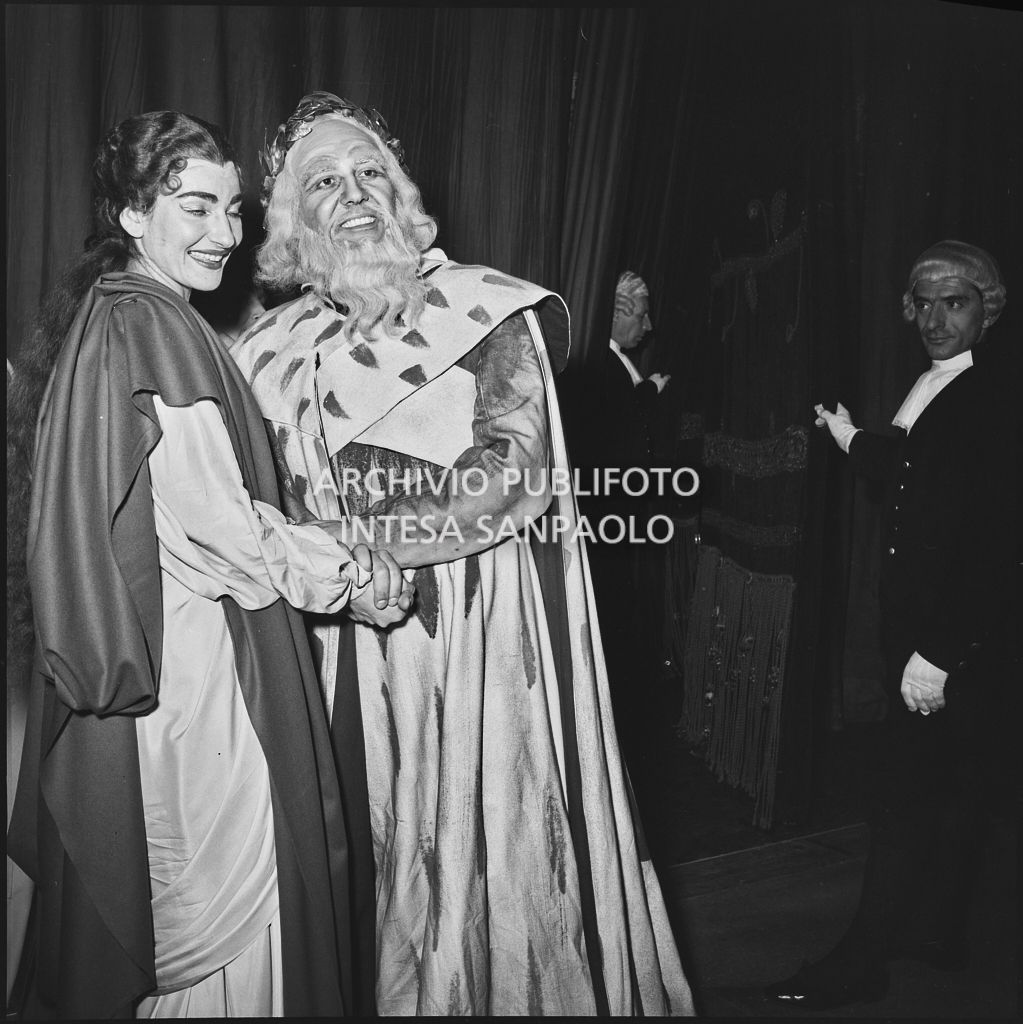 La soprano Maria Callas e il basso Nicola Zaccaria, in abiti di scena, dietro le quinte del Teatro alla Scala al termine della rappresentazione dell'opera "Norma" di Vincenzo Bellini, diretta da Antonino Votto, con la regia di Margherita Wallmann, che inaugura la stagione lirica 1955-1956