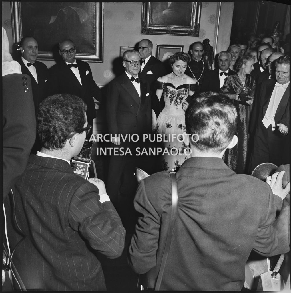 Il presidente della Repubblica Giovanni Gronchi e la moglie Carla Bissatini tra la folla e i fotografi in occasione della serata inaugurale della stagione lirica 1955-1956 con l'opera "Norma" di Vincenzo Bellini, diretta da Antonino Votto, con la regia di Margherita Wallmann
