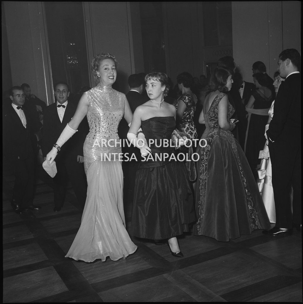 La contessa Alma Maria Lami con Oriana Fallaci nel foyer del Teatro alla Scala in occasione della serata inaugurale della stagione lirica 1955-1956 con l'opera "Norma" di Vincenzo Bellini, diretta da Antonino Votto, con la regia di Margherita Wallmann