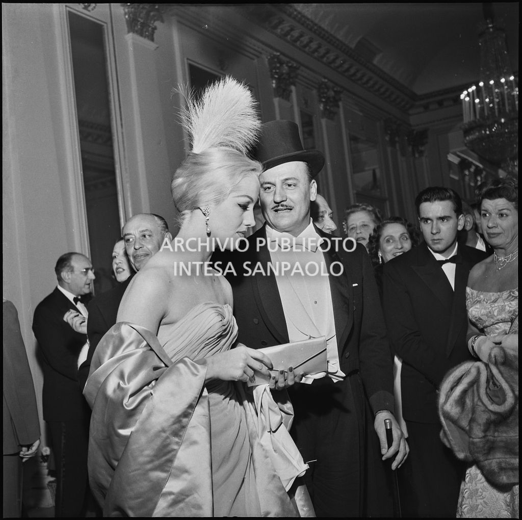 Lo stilista Pierre Balmain e Barbara Balmain all'inaugurazione della stagione lirica 1956-1957 del Teatro alla Scala con l'opera "Aida" di Giuseppe Verdi, diretta da Antonino Votto, con la regia di Franco Enriquez