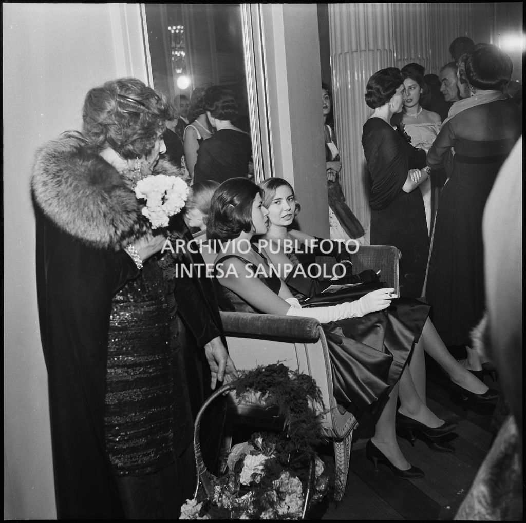 Silvia e Rossana Tofanelli sedute nel foyer del Teatro alla Scala in occasione della serata inaugurale della stagione lirica 1956-1957 con l'opera "Aida" di Giuseppe Verdi, diretta da Antonino Votto, con la regia di Franco Enriquez