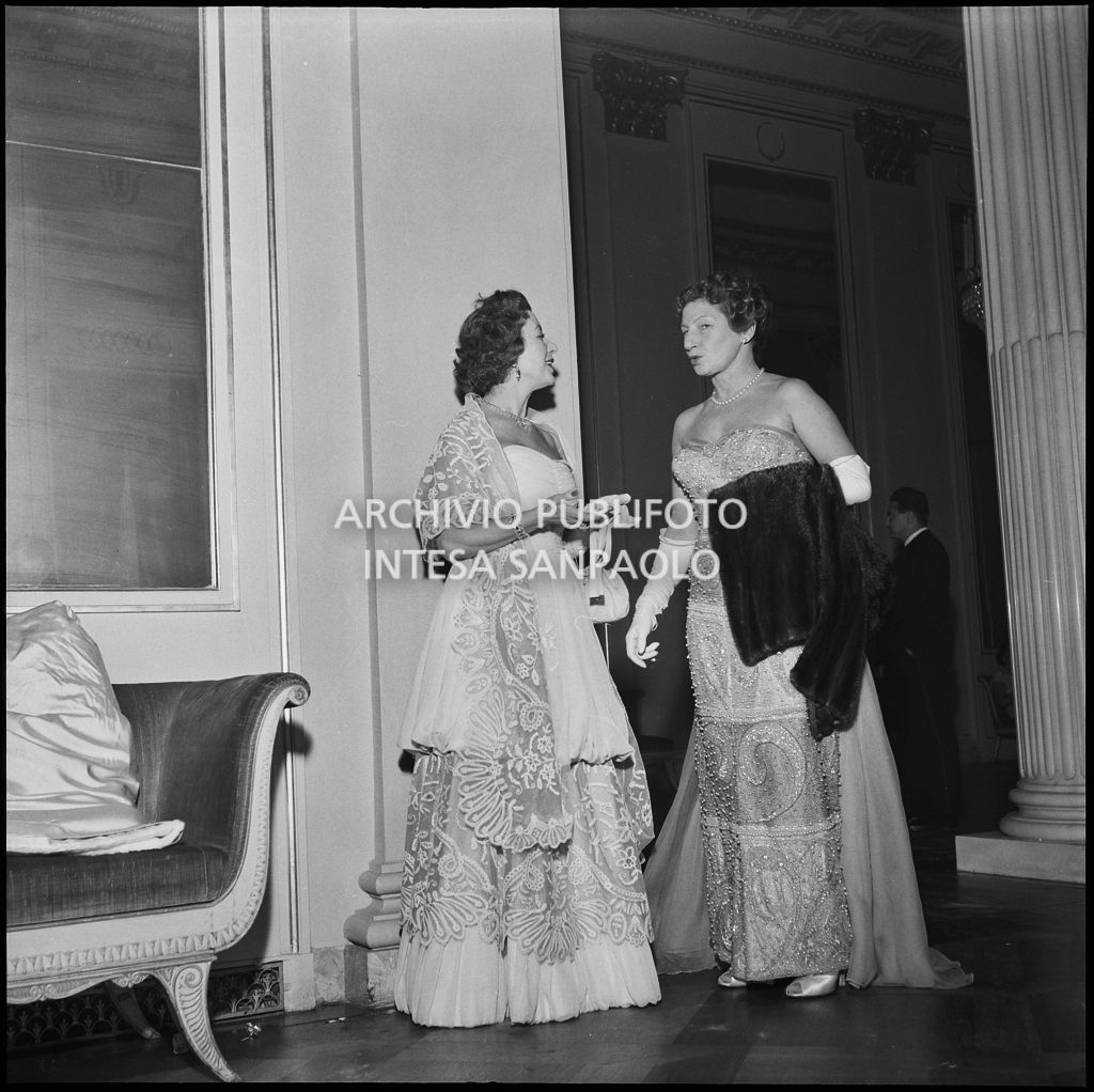 Due spettatrici nel foyer del Teatro alla Scala in occasione dell'inaugurazione della stagione lirica 1956-1957 con l'opera "Aida" di Giuseppe Verdi, diretta da Antonino Votto, con la regia di Franco Enriquez