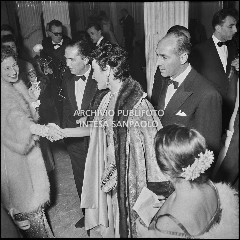 Silvana Pampanini saluta un'ammiratrice nel foyer del Teatro alla Scala in occasione dell'inaugurazione della stagione lirica 1956-1957 con l'opera "Aida" di Giuseppe Verdi, diretta da Antonino Votto, con la regia di Franco Enriquez