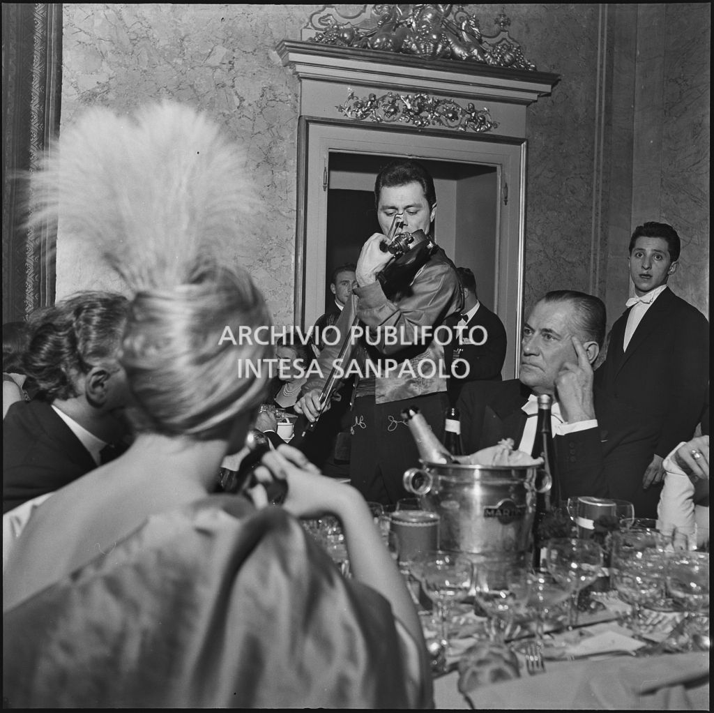 Un violinista si esibisce durante la cena che segue la serata inaugurale della stagione lirica 1956-1957 del Teatro alla Scala con l'opera "Aida" di Giuseppe Verdi, diretta da Antonino Votto, con la regia di Franco Enriquez
