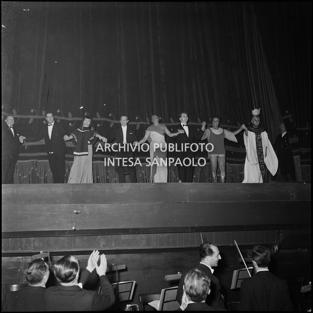 Gli artisti sul palcoscenico del Teatro alla Scala ricevono l'applauso del pubblico in occasione della serata inaugurale della stagione lirica 1956-1957 con l'opera "Aida" di Giuseppe Verdi, diretta da Antonino Votto, con la regia di Franco Enriquez