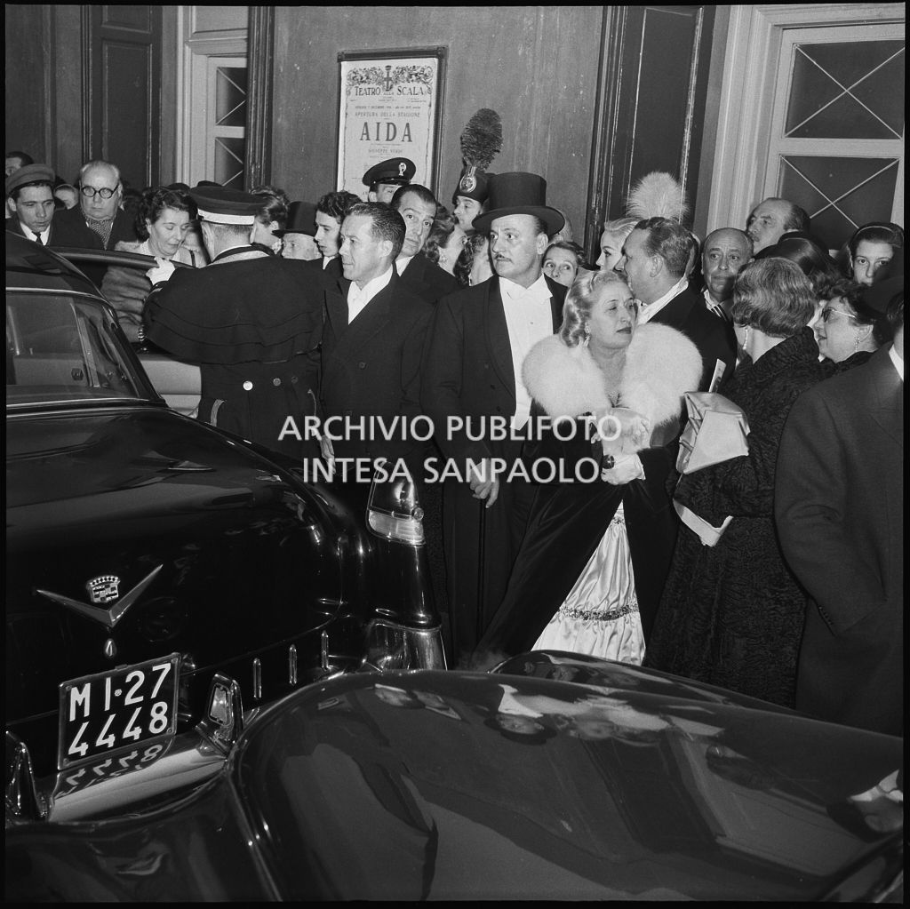 Spettatori all'uscita dal Teatro alla Scala dopo la serata inaugurale della stagione lirica 1956-1957 con l'opera "Aida" di Giuseppe Verdi, diretta da Antonino Votto, con la regia di Franco Enriquez