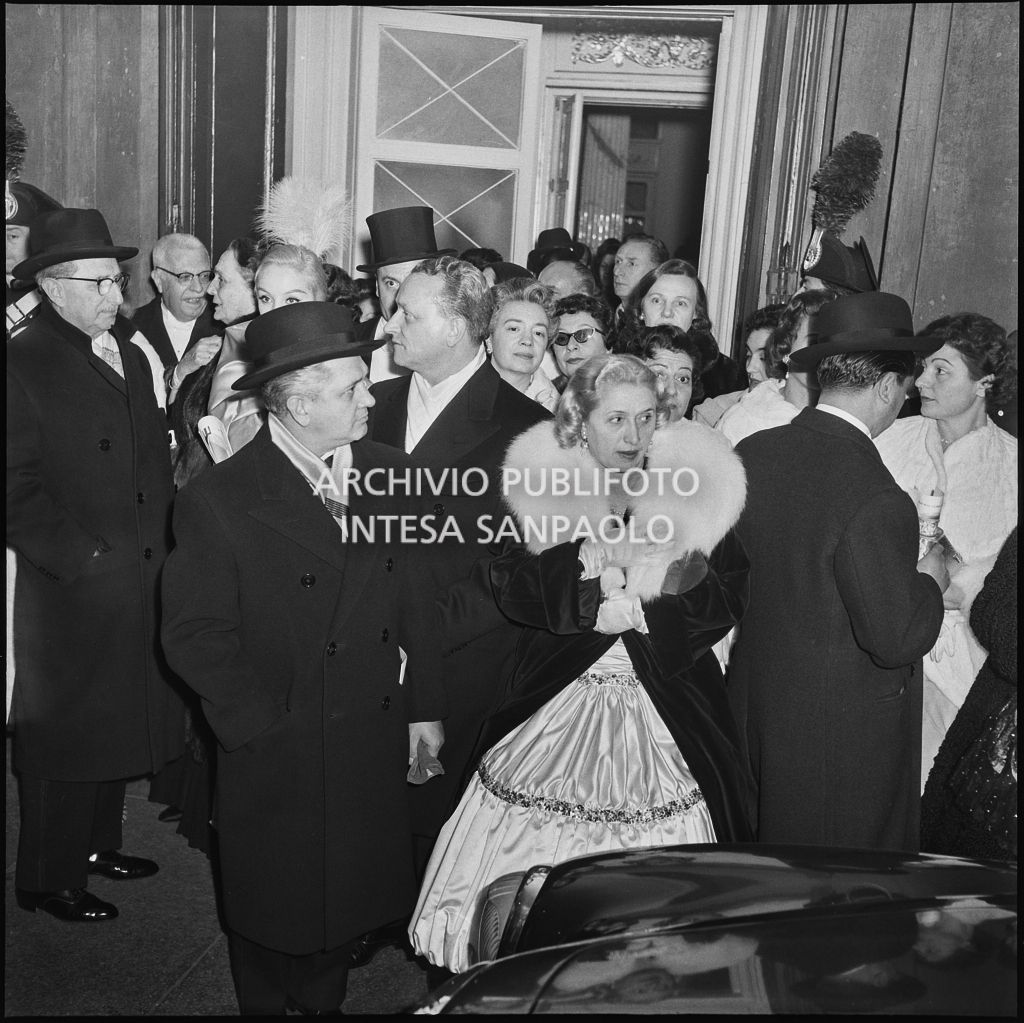 Spettatori all'uscita dal Teatro alla Scala dopo la serata inaugurale della stagione lirica 1956-1957 con l'opera "Aida" di Giuseppe Verdi, diretta da Antonino Votto, con la regia di Franco Enriquez