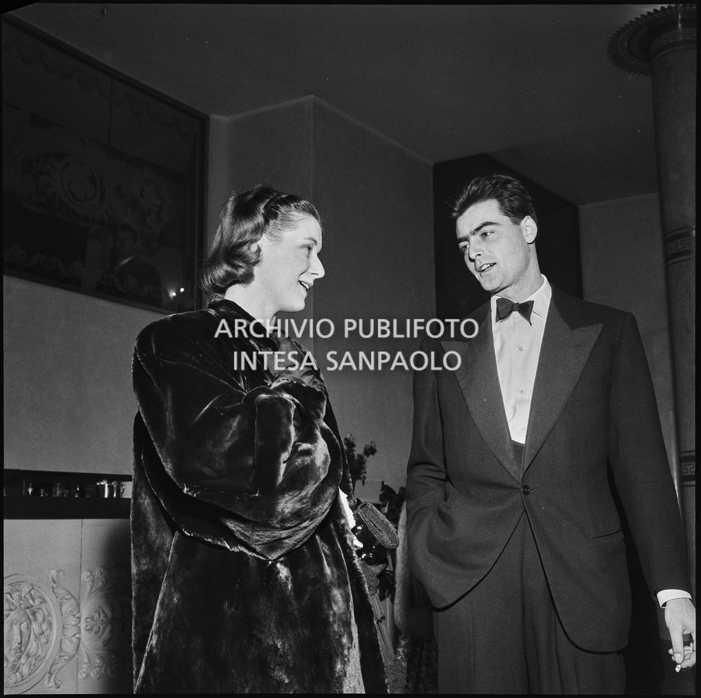 Due spettatori nel foyer della Piccola Scala in occasione della serata inaugurale della stagione lirica 1956-1957 con l'opera "La cecchina ossia la buona figliola" di Niccolò Vito Piccinni, diretta da Nino Sanzogno, con la regia di Franco Zeffirelli