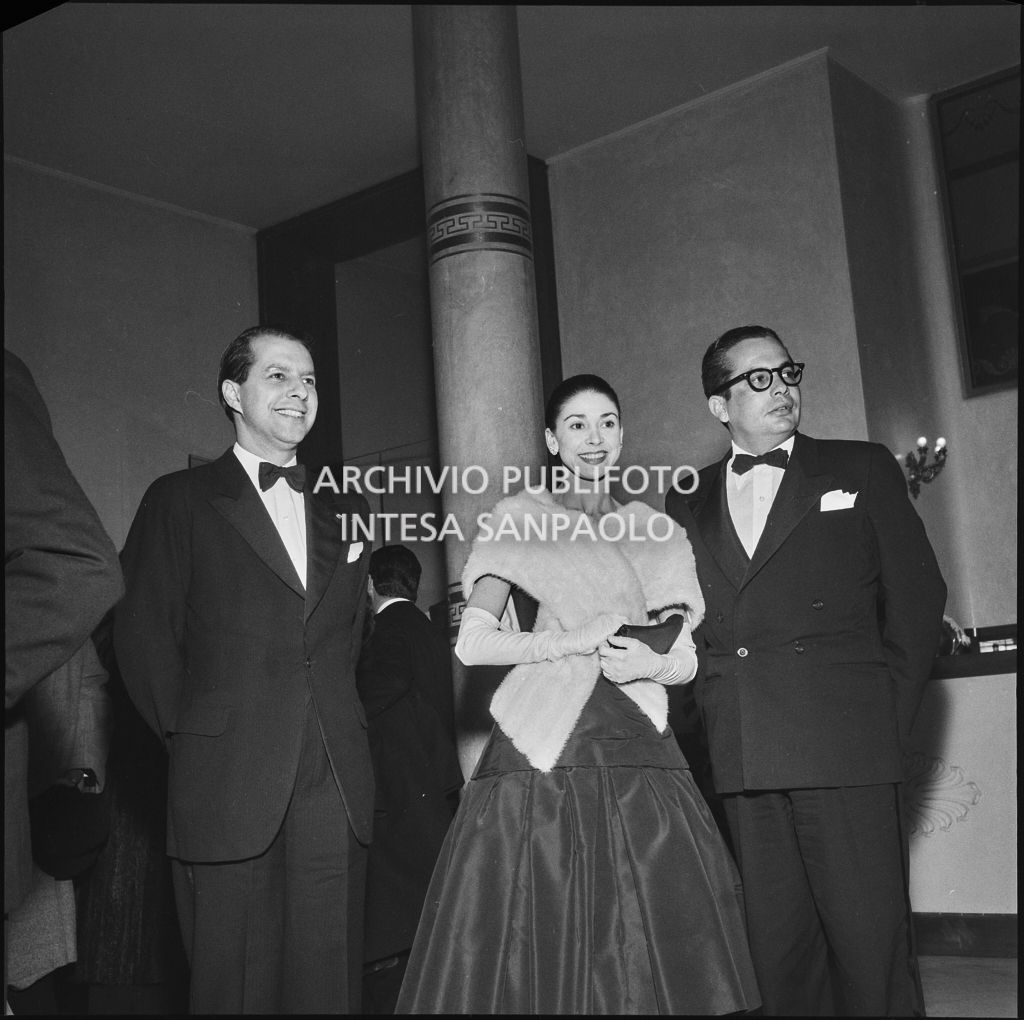 Margot Fonteyn tra Vallarino e il marito Roberto Arias nel foyer della Piccola Scala in occasione della serata inaugurale della stagione lirica 1956-1957 con l'opera "La cecchina ossia la buona figliola" di Niccolò Vito Piccinni, diretta da Nino Sanzogno, con la regia di Franco Zeffirelli