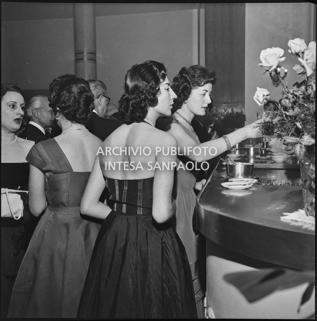 Eugenia Busnello con altre spettatrici al bar della Piccola Scala in occasione della serata inaugurale della stagione lirica 1956-1957 con l'opera "La cecchina ossia la buona figliola" di Niccolò Vito Piccinni, diretta da Nino Sanzogno, con la regia di Franco Zeffirelli