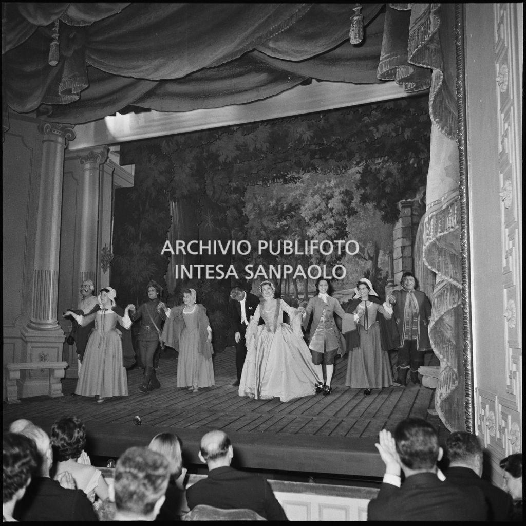 Gli artisti e il direttore d'orchestra Nino Sanzogno sul palcoscenico alla fine della rappresentazione dell'opera "La cecchina ossia la buona figliola" di Niccolò Vito Piccinni, diretta da Nino Sanzogno, con la regia di Franco Zeffirelli, con al quale si è inagurata la stagione lirica 1956-1957 della Piccola Scala