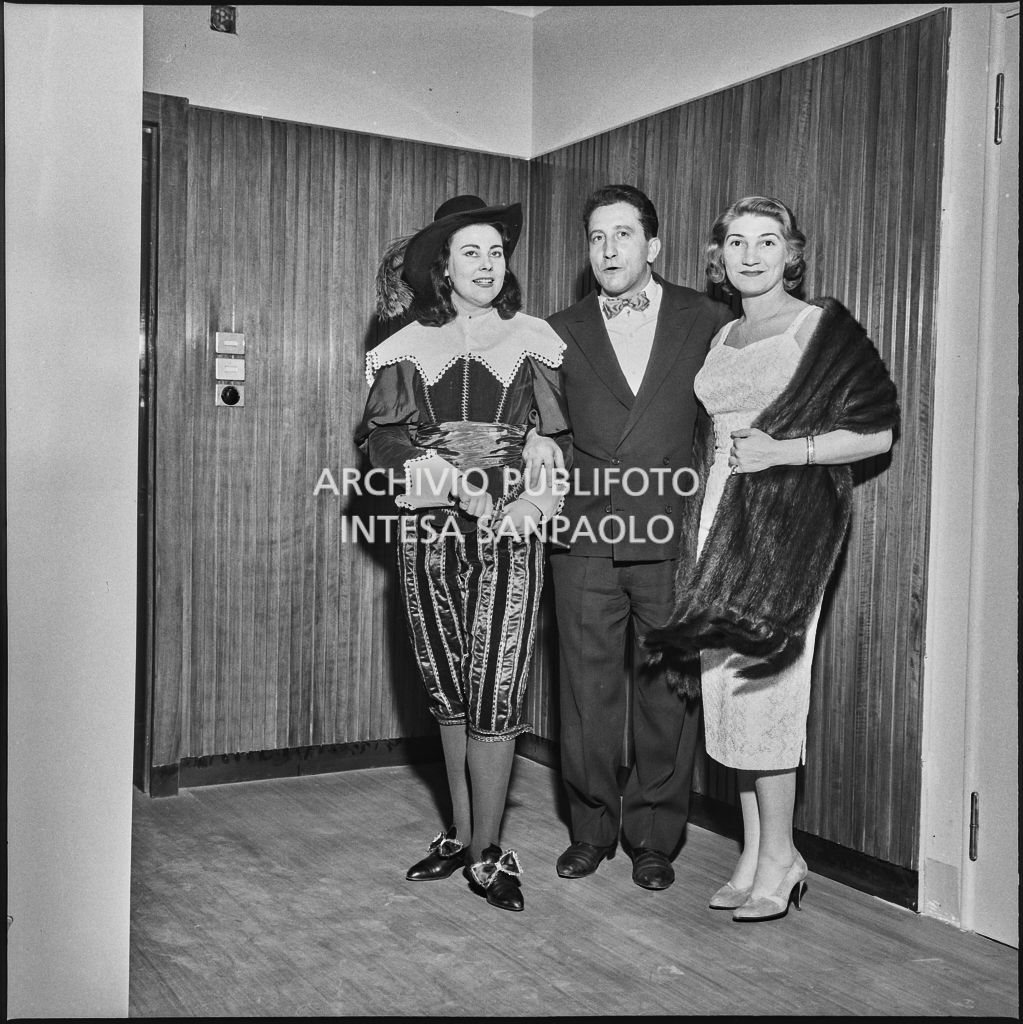 Il soprano Eugenia Ratti, in costume di scena, con due spettatori al Teatro alla Scala in occasione della serata inaugurale della stagione lirica 1957-1958, aperta con l'opera "Un ballo in maschera", di Giuseppe Verdi, diretta da Gianandrea Gavazzeni con la regia di Margherita Wallmann