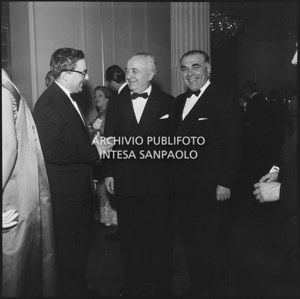 Il ministro del Lavoro e della Previdenza sociale Ezio Vigorelli con altri spettatori nel foyer del Teatro alla Scala in occasione della serata inaugurale della stagione lirica 1957-1958 con l'opera "Un ballo in maschera", di Giuseppe Verdi, diretta da Gianandrea Gavazzeni con la regia di Margherita Wallmann