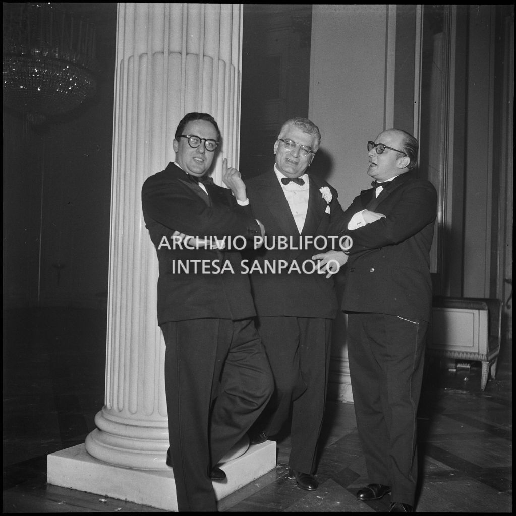 Tre spettatori nel foyer del Teatro alla Scala in occasione della serata inaugurale della stagione lirica 1957-1958 con l'opera "Un ballo in maschera", di Giuseppe Verdi, diretta da Gianandrea Gavazzeni con la regia di Margherita Wallmann