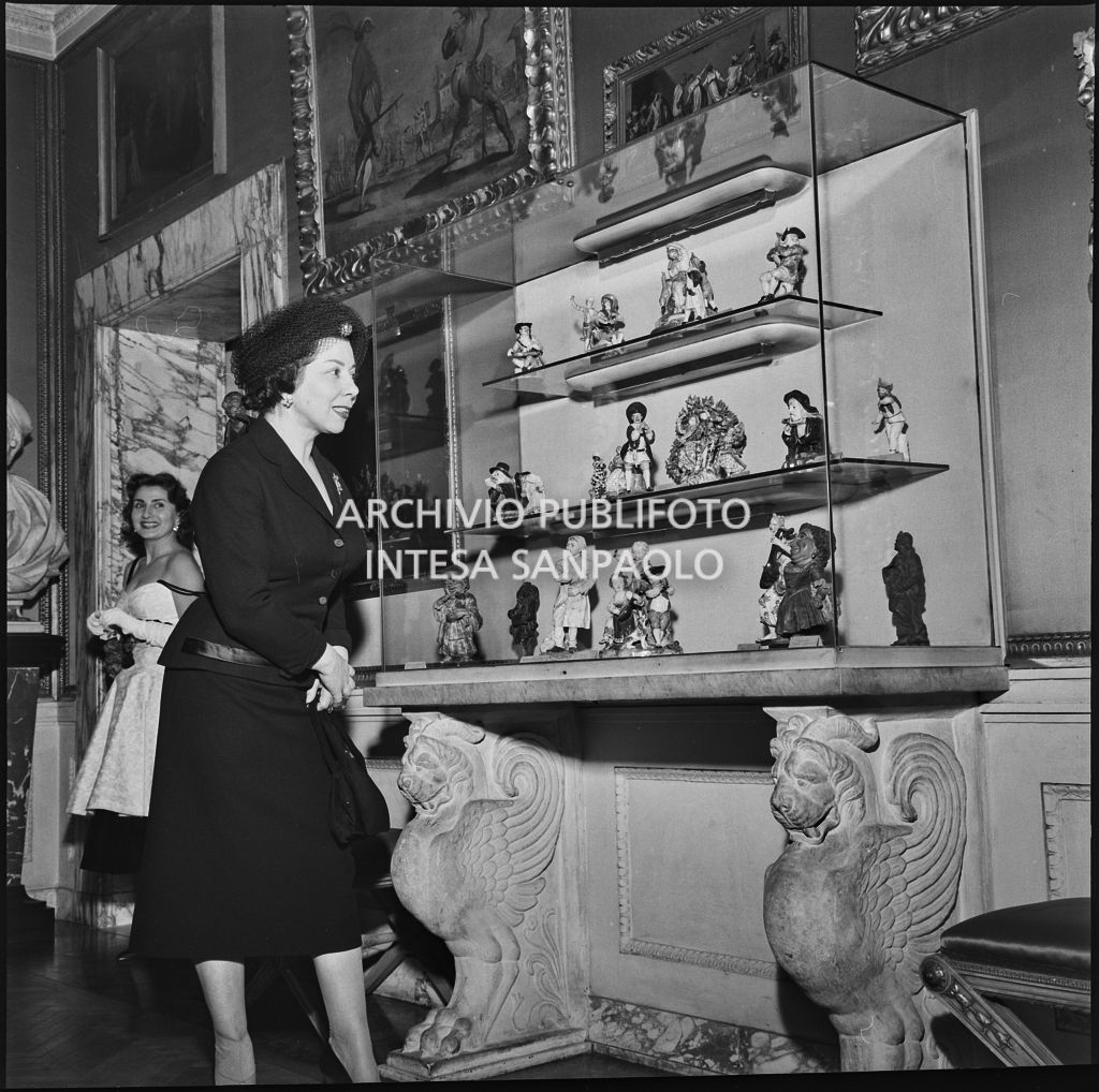 Il mezzosoprano Giulietta Simionato osserva una vetrina espositiva del museo del Teatro alla Scala in occasione della serata inaugurale della stagione lirica 1957-1958 con l'opera "Un ballo in maschera", di Giuseppe Verdi, diretta da Gianandrea Gavazzeni con la regia di Margherita Wallmann