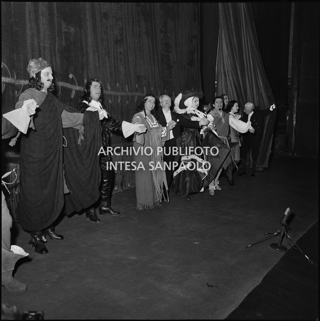 Gli artisti e il direttore d'orchestra Gianandrea Gavazzeni sul palco del Teatro alla Scala al termine dell'opera "Un ballo in maschera", di Giuseppe Verdi, diretta da Gianandrea Gavazzeni con la regia di Margherita Wallmann, che inaugura la stagione lirica 1957-1958