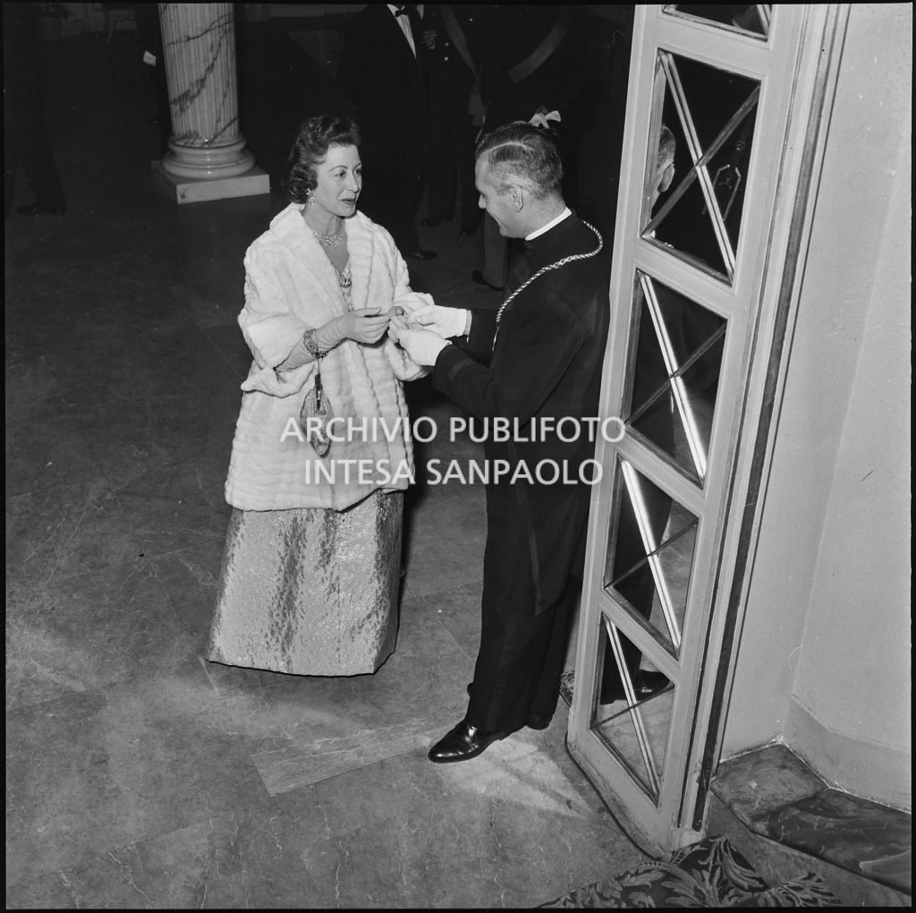 Una spettatrice discute con una maschera del Teatro alla Scala in occasione della serata inaugurale della stagione lirica 1957-1958 con l'opera "Un ballo in maschera", di Giuseppe Verdi, diretta da Gianandrea Gavazzeni con la regia di Margherita Wallmann