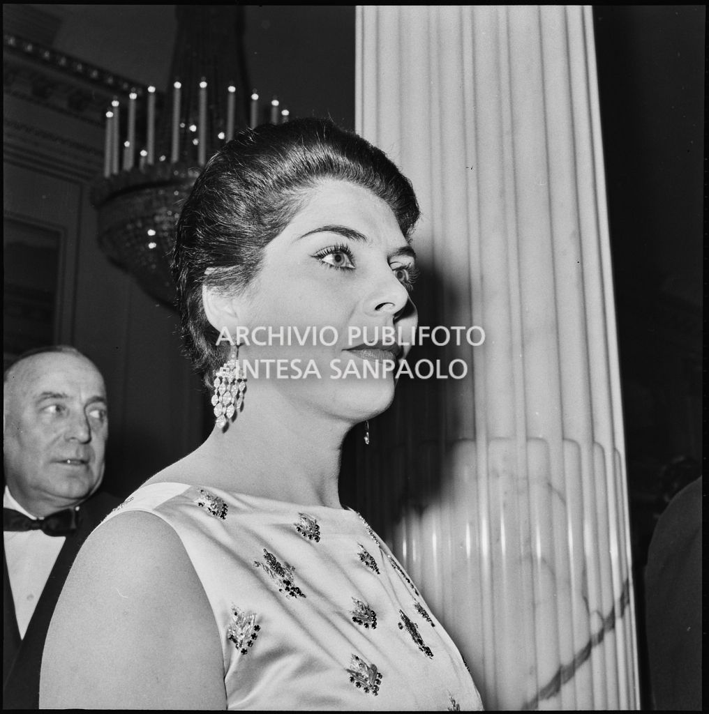 Una spettatrice nel foyer del Teatro alla Scala in occasione della serata inaugurale della stagione lirica 1957-1958 con l'opera "Un ballo in maschera", di Giuseppe Verdi, diretta da Gianandrea Gavazzeni con la regia di Margherita Wallmann