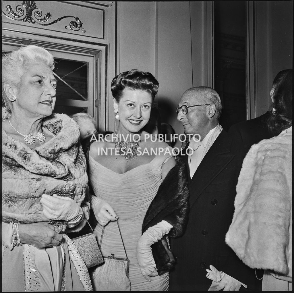 L'ambasciatore americano James David Zellerbach con la moglie e la figlia nel foyer del Teatro alla Scala in occasione della serata inaugurale della stagione lirica 1957-1958 con l'opera "Un ballo in maschera", di Giuseppe Verdi, diretta da Gianandrea Gavazzeni con la regia di Margherita Wallmann