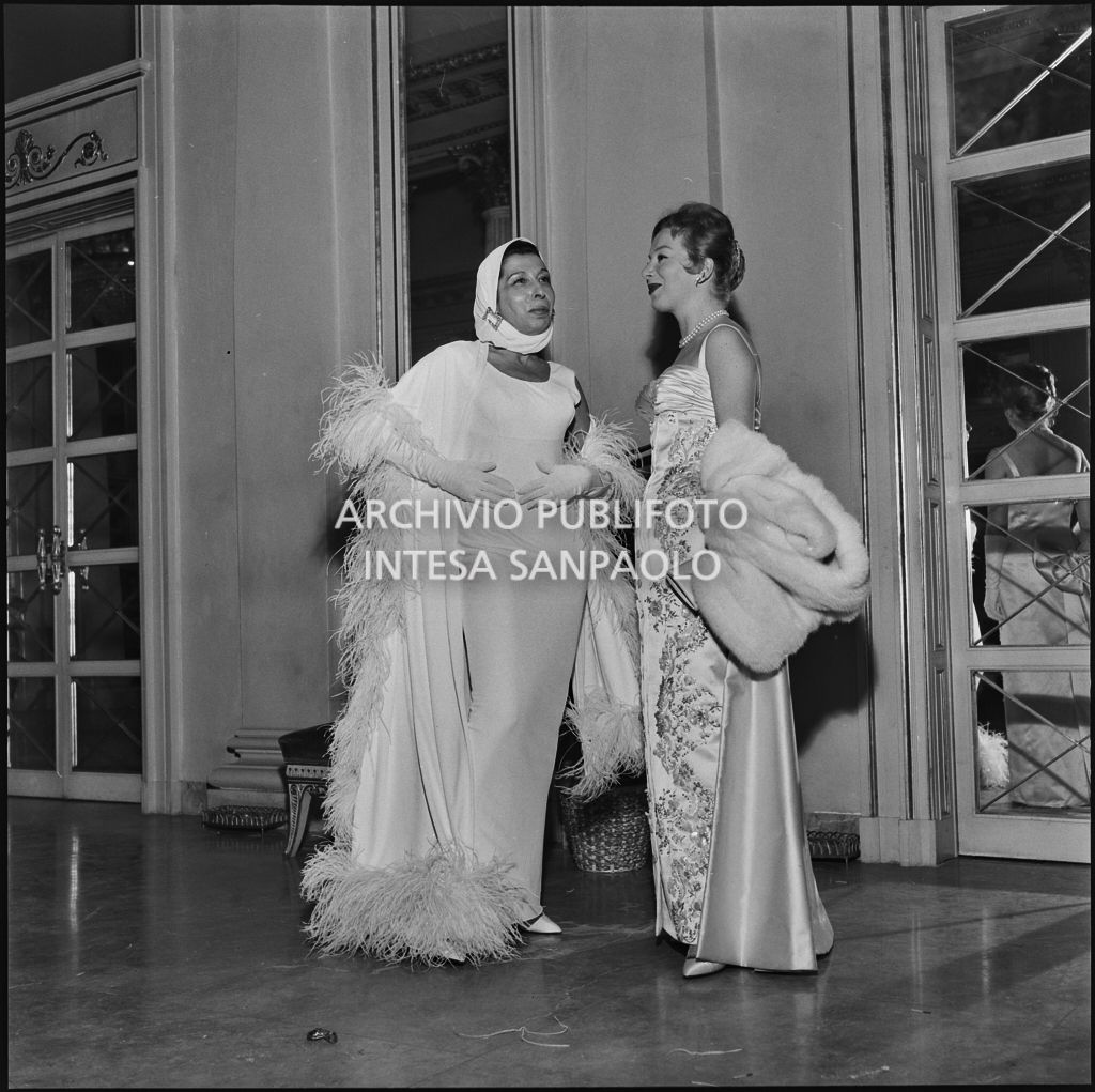 Maria Pica e Gioia Lombroso nel foyer del Teatro alla Scala in occasione della serata inaugurale della stagione lirica 1957-1958 con l'opera "Un ballo in maschera", di Giuseppe Verdi, diretta da Gianandrea Gavazzeni con la regia di Margherita Wallmann