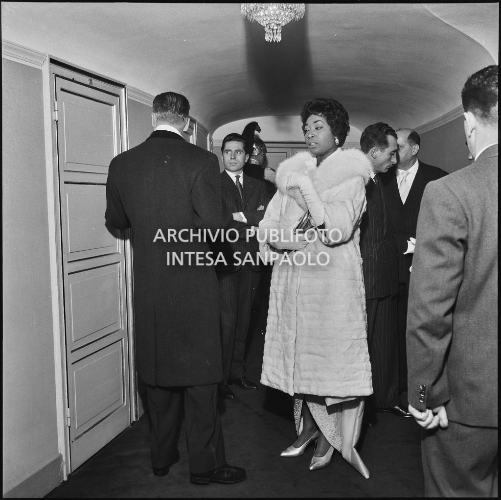 Il soprano Gloria Davy ed altri spettatori al Teatro alla Scala in occasione della serata inaugurale della stagione lirica 1957-1958 con l'opera "Un ballo in maschera", di Giuseppe Verdi, diretta da Gianandrea Gavazzeni con la regia di Margherita Wallmann
