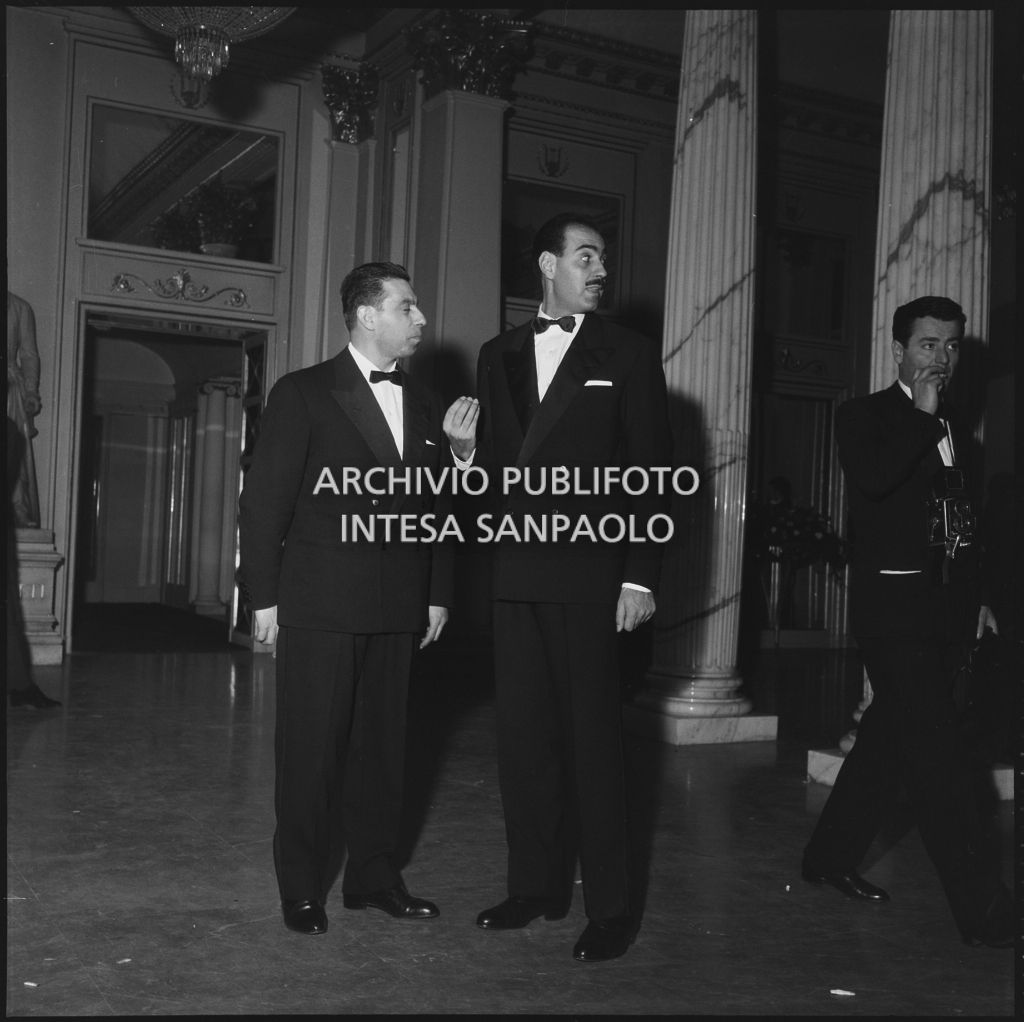 Due spettatori nel foyer del Teatro alla Scala in occasione della serata inaugurale della stagione lirica 1957-1958 con l'opera "Un ballo in maschera", di Giuseppe Verdi, diretta da Gianandrea Gavazzeni con la regia di Margherita Wallmann