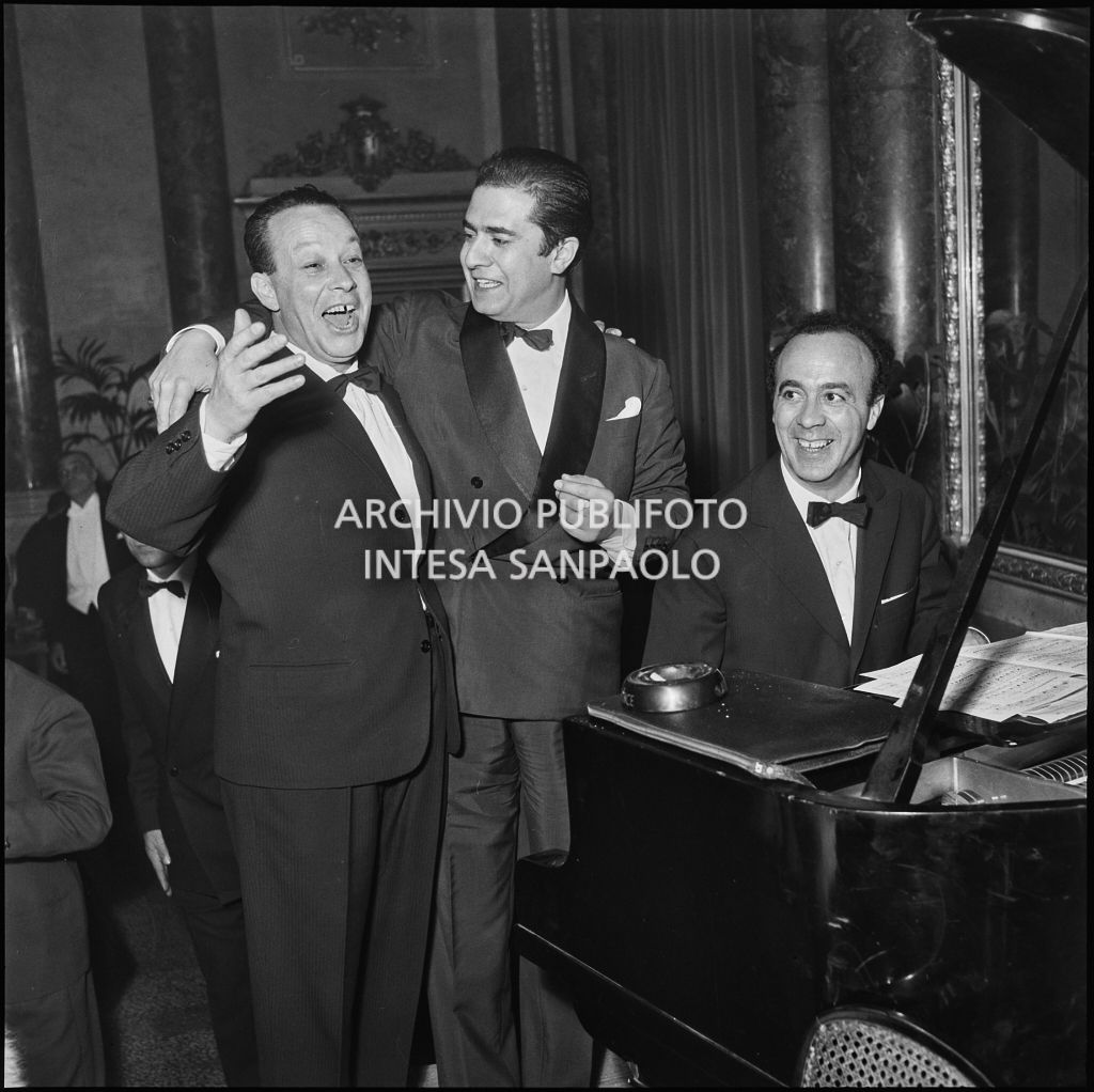 Il tenore Giuseppe Di Stefano, accompagnato dal pianoforte, canta con un altra persona al ristorante dopo la rappresentazione dell'opera di Giuseppe Verdi "Un ballo in maschera", diretta da Gianandrea Gavazzeni e con la regia di Margherita Wallmann con la quale è stata inaugurata la stagione lirica 1957-1958 del Teatro alla Scala