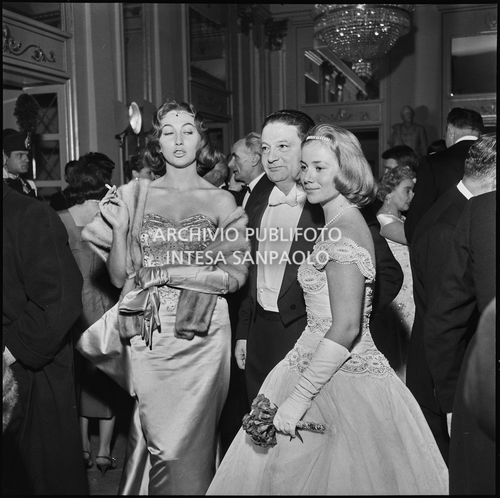 Pini Carnevale e Ingeborg Ferro nel foyer del Teatro alla Scala in occasione della serata inaugurale della stagione lirica 1957-1958 con l'opera "Un ballo in maschera", di Giuseppe Verdi, diretta da Gianandrea Gavazzeni con la regia di Margherita Wallmann