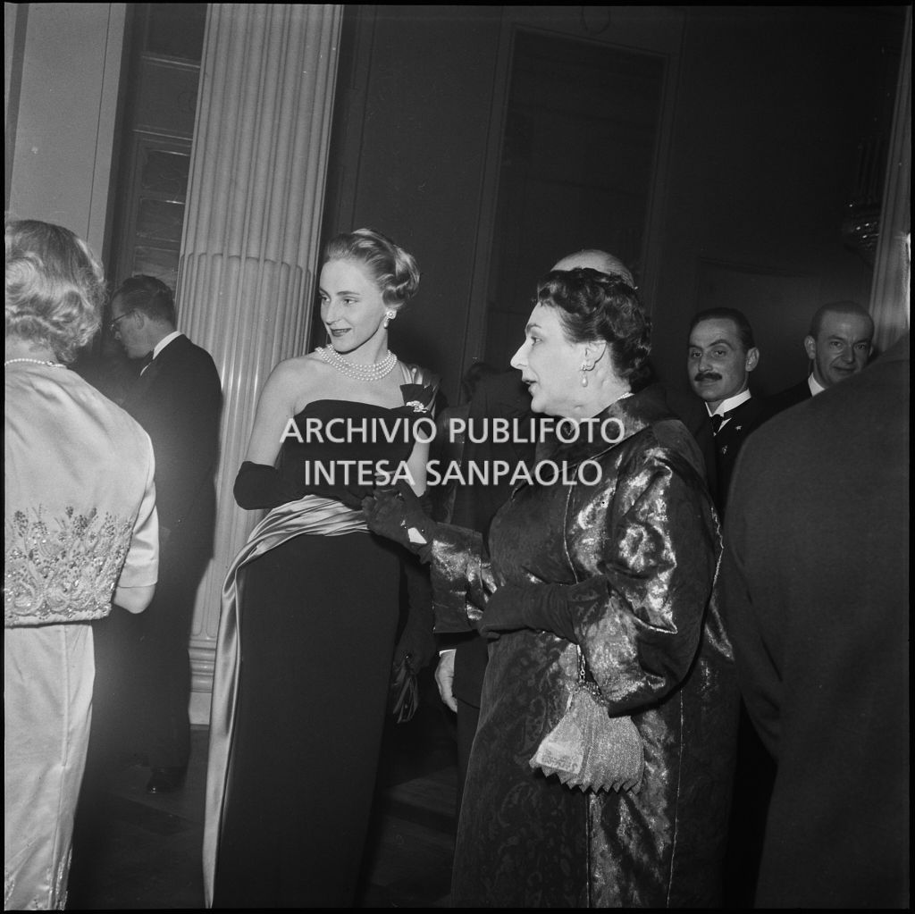 Emanuela di Castelbarco con la madre Wally Toscanini e altri spettatori nel foyer del Teatro alla Scala in occasione della serata inaugurale della stagione lirica 1957-1958 con l'opera "Un ballo in maschera", di Giuseppe Verdi, diretta da Gianandrea Gavazzeni con la regia di Margherita Wallmann