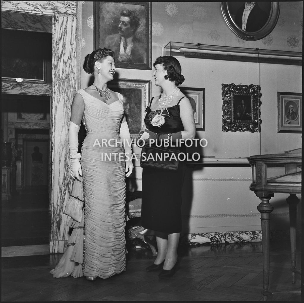 La figlia dell'ambasciatore americano James David Zellerbach con un'altra spettatrice nel museo del Teatro alla Scala in occasione della serata inaugurale della stagione lirica 1957-1958 con l'opera "Un ballo in maschera", di Giuseppe Verdi, diretta da Gianandrea Gavazzeni con la regia di Margherita Wallmann