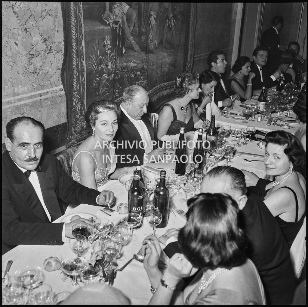 Tavolo di commensali al ristorante dopo la rappresentazione dell'opera di Giuseppe Verdi "Un ballo in maschera", diretta da Gianandrea Gavazzeni e con la regia di Margherita Wallmann con la quale è stata inaugurata la stagione lirica 1957-1958 del Teatro alla Scala
