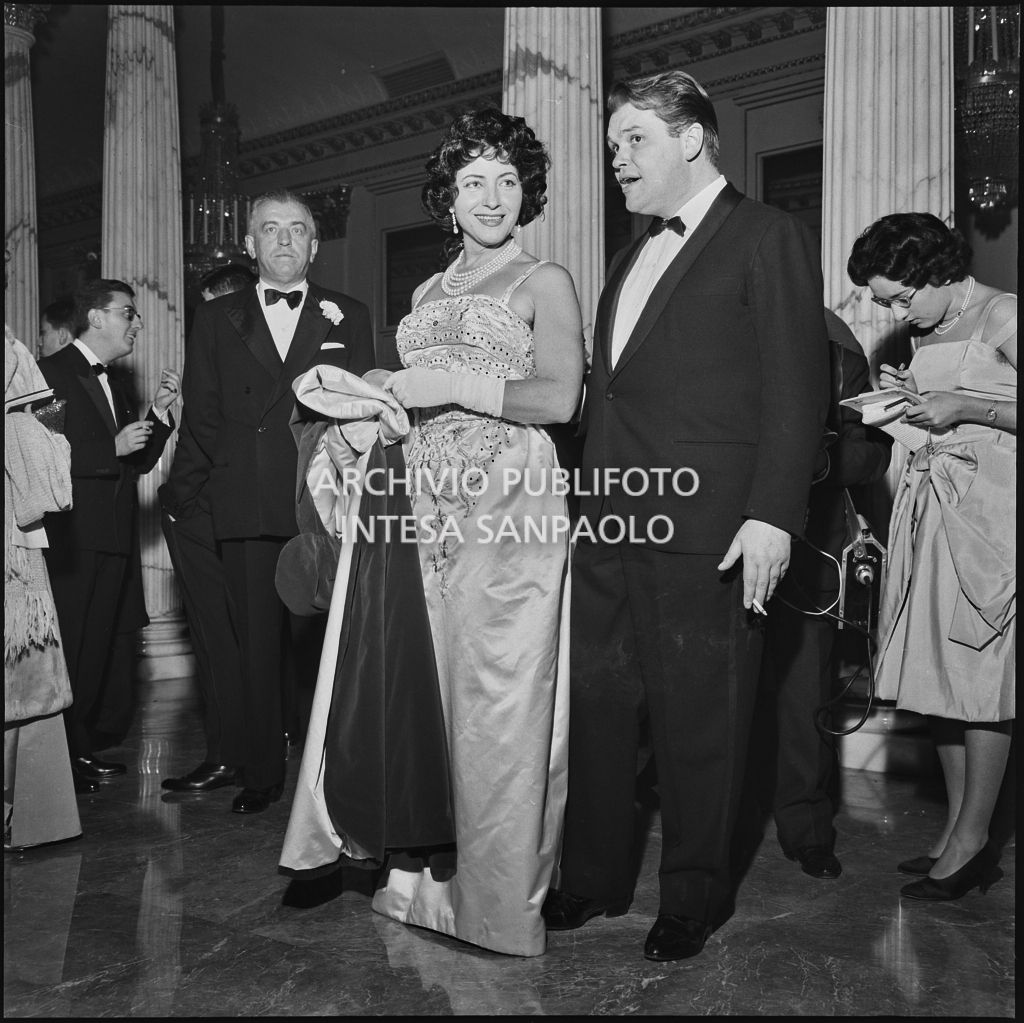 Il soprano Clara Petrella con un altro spettatore nel foyer del Teatro alla Scala in occasione della serata inaugurale della stagione lirica 1958-1959 con l'opera "Turandot", di Giacomo Puccini, diretta da Antonino Votto con la regia di Margherita Wallmann