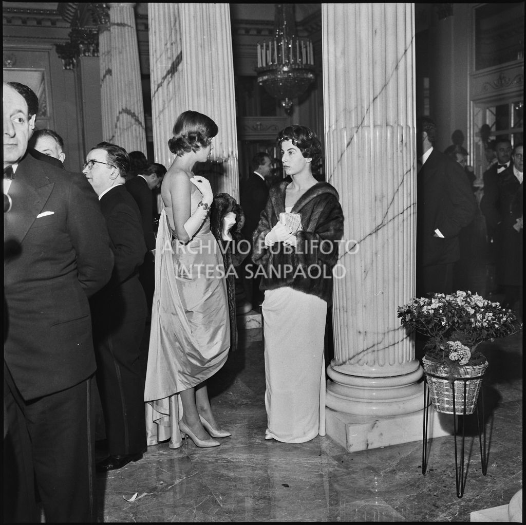 La figlia del ministro per i Rapporti con il Parlamento (a sinistra), Dino Del Bo, conversa con Franca Valsecchi nel foyer del Teatro alla Scala in occasione della serata inaugurale della stagione lirica 1958-1959 con l'opera "Turandot", di Giacomo Puccini, diretta da Antonino Votto con la regia di Margherita Wallmann