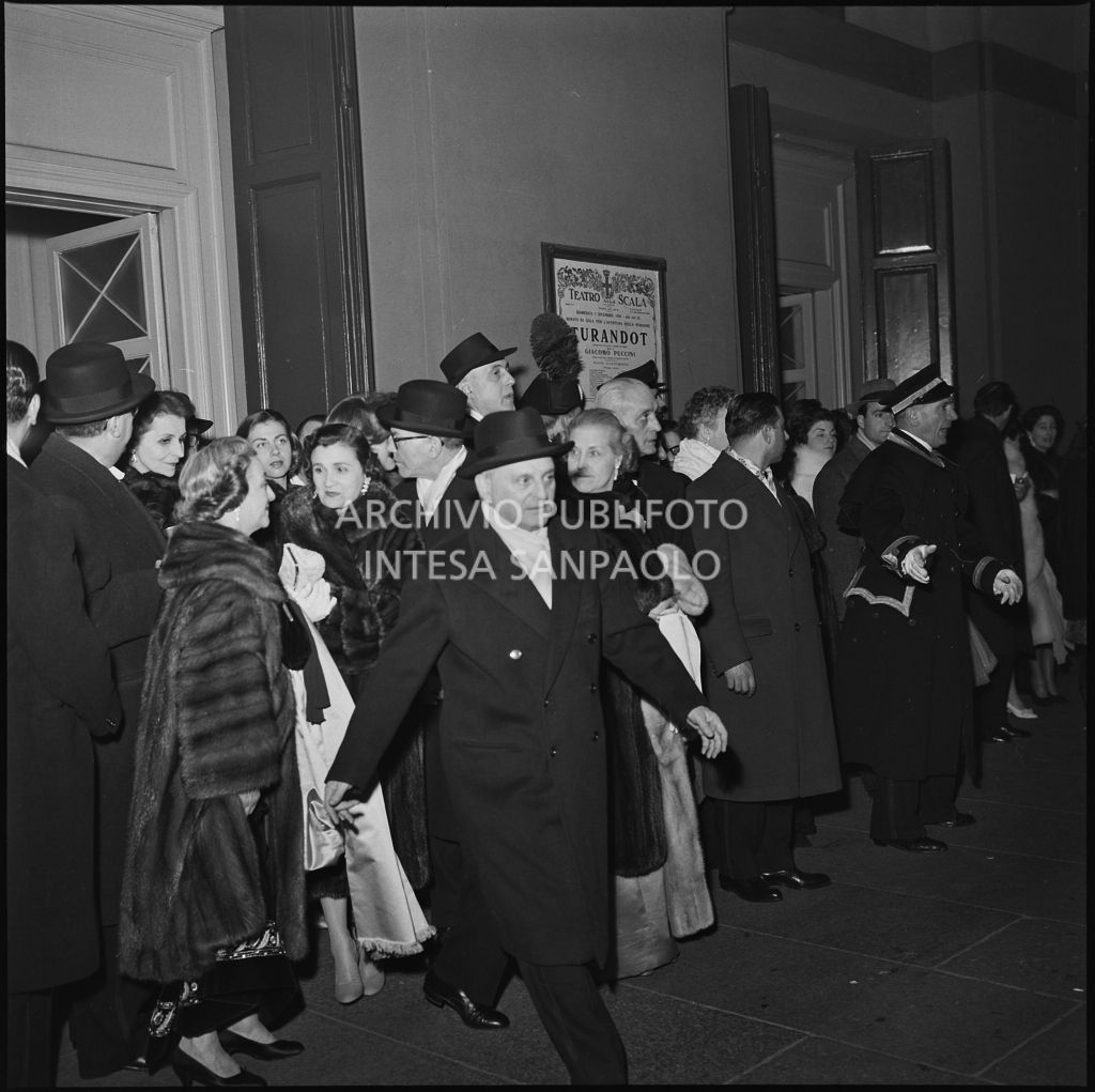 Gli spettatori attendono l'arrivo delle automobili, all'uscita del Teatro alla scala, al termine dell'opera "Turandot", di Giacomo Puccini, diretta da Antonino Votto con la regia di Margherita Wallmann, che inaugura la stagione lirica 1958-1959