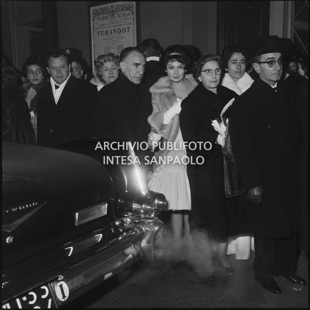 Spettatori in attesa dell'automobile all'uscita dal Teatro alla Scala al termine della serata inaugurale della stagione lirica 1958-1959 con l'opera "Turandot", di Giacomo Puccini, diretta da Antonino Votto con la regia di Margherita Wallmann