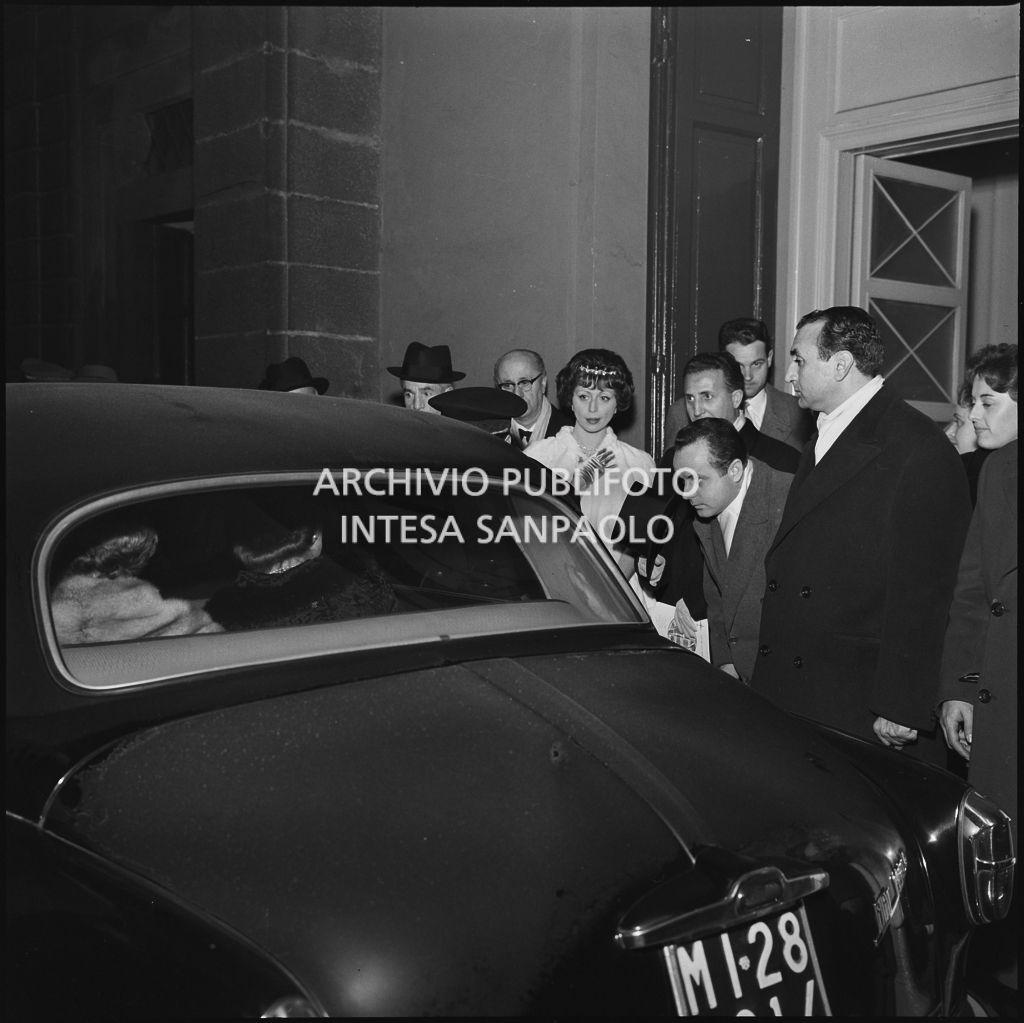 Il conte Franco Cella di Rivara, la moglie ed altri spettatori in attesa dell'automobile all'uscita dal Teatro alla Scala al termine della serata inaugurale della stagione lirica 1958-1959 con l'opera "Turandot", di Giacomo Puccini, diretta da Antonino Votto con la regia di Margherita Wallmann