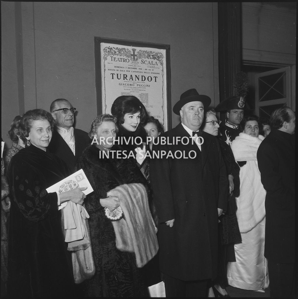 Eletta Polvani ed altri spettatori in attesa dell'automobile all'uscita dal Teatro alla Scala al termine della serata inaugurale della stagione lirica 1958-1959 con l'opera "Turandot", di Giacomo Puccini, diretta da Antonino Votto con la regia di Margherita Wallmann