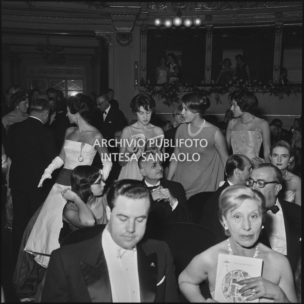 Le sorella Caperano e la madre nella platea del Teatro alla Scala, gremita di gente, in occasione della serata inaugurale della stagione lirica 1958-1959 con l'opera "Turandot", di Giacomo Puccini, diretta da Antonino Votto con la regia di Margherita Wallmann