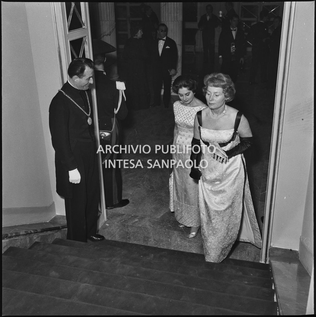 Due spettatrici si avviano ai palchi del Teatro alla Scala in occasione della serata inaugurale della stagione lirica 1958-1959 con l'opera "Turandot", di Giacomo Puccini, diretta da Antonino Votto con la regia di Margherita Wallmann