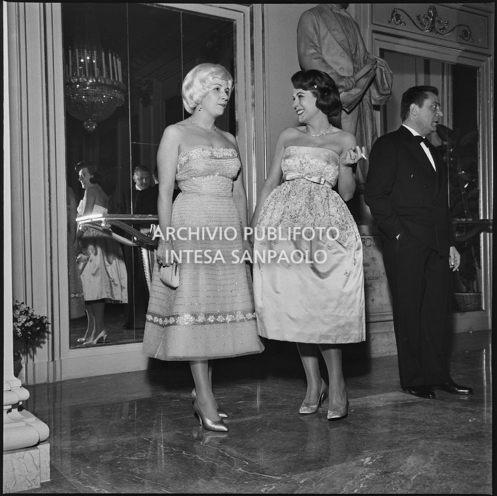 Silvana Polli con un'altra spettatrice nel foyer del Teatro alla Scala in occasione della serata inaugurale della stagione lirica 1958-1959 con l'opera "Turandot", di Giacomo Puccini, diretta da Antonino Votto con la regia di Margherita Wallmann