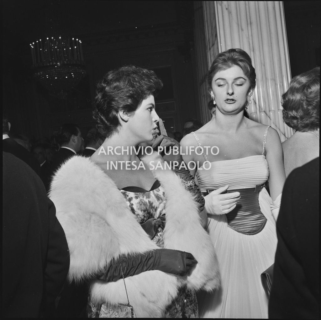 Due spettatrici nel foyer del Teatro alla Scala in occasione della serata inaugurale della stagione lirica 1958-1959 con l'opera "Turandot", di Giacomo Puccini, diretta da Antonino Votto con la regia di Margherita Wallmann