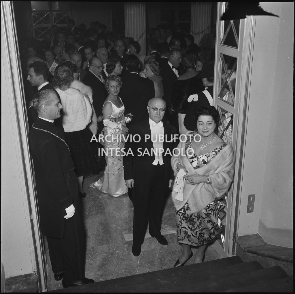 I signori Buzzi nel foyer del Teatro alla Scala, gremito di gente, in occasione della serata inaugurale della stagione lirica 1958-1959 con l'opera "Turandot", di Giacomo Puccini, diretta da Antonino Votto con la regia di Margherita Wallmann