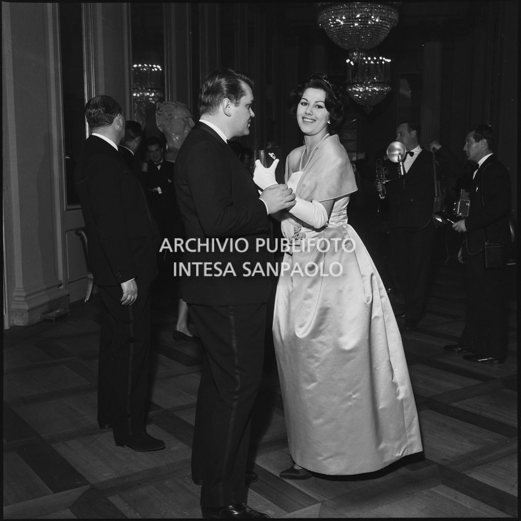 Maria Elisa Marzotto con un altro spettatore nel foyer del Teatro alla Scala in occasione della serata inaugurale della stagione lirica 1958-1959 con l'opera "Turandot", di Giacomo Puccini, diretta da Antonino Votto con la regia di Margherita Wallmann