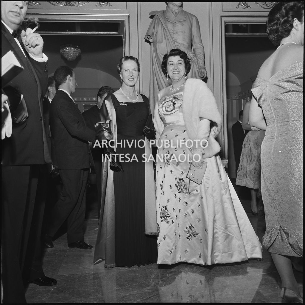 Due spettatrici nel foyer del Teatro alla Scala, gremito di gente, in occasione della serata inaugurale della stagione lirica 1958-1959 con l'opera "Turandot", di Giacomo Puccini, diretta da Antonino Votto con la regia di Margherita Wallmann