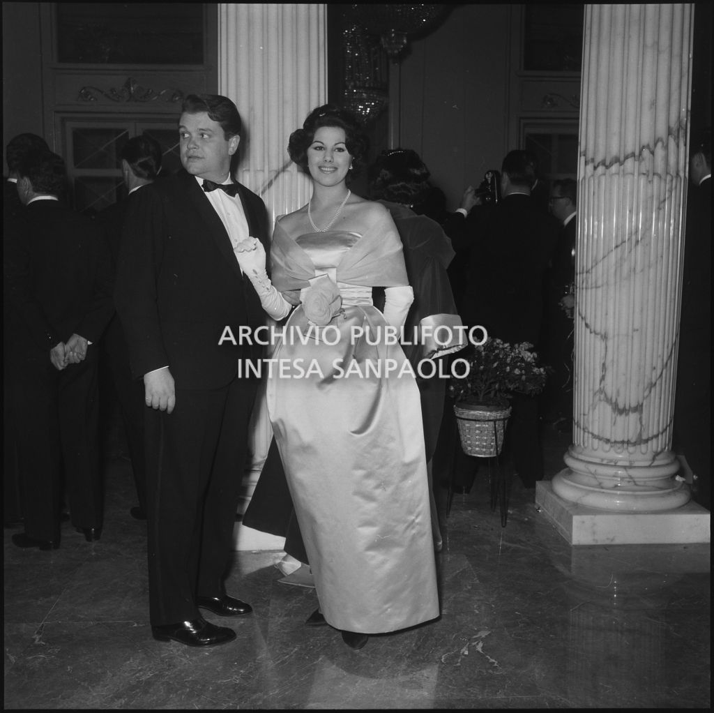 Maria Elisa Marzotto con un altro spettatore nel foyer del Teatro alla Scala in occasione della serata inaugurale della stagione lirica 1958-1959 con l'opera "Turandot", di Giacomo Puccini, diretta da Antonino Votto con la regia di Margherita Wallmann