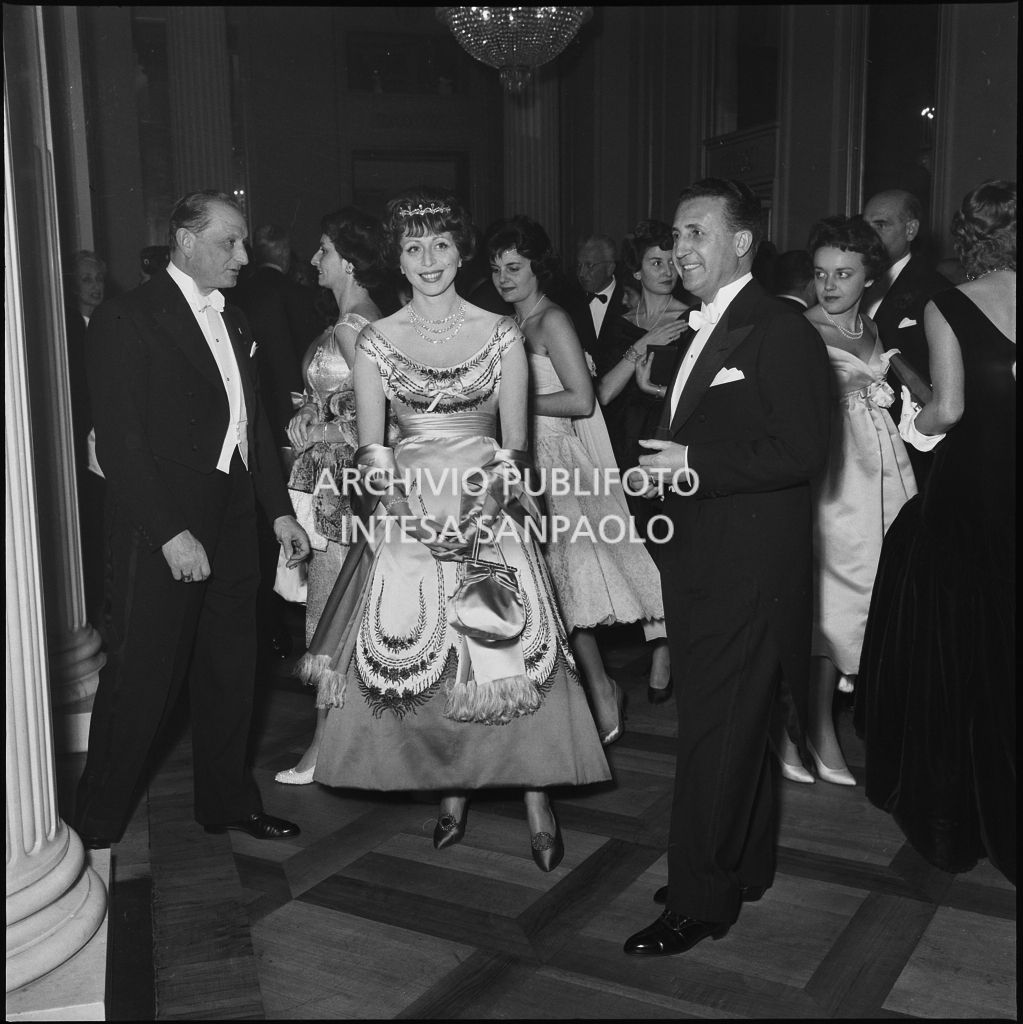 Il conte Franco Cella di Rivara con la moglie nel foyer del Teatro alla Scala, gremito di gente, in occasione della serata inaugurale della stagione lirica 1958-1959 con l'opera "Turandot", di Giacomo Puccini, diretta da Antonino Votto con la regia di Margherita Wallmann