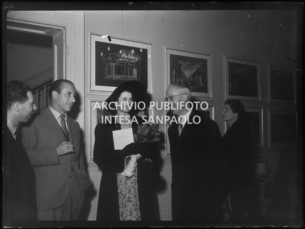 Il professore Guido Calogero, filosofo e storico della filosofia, docente nelle Università di Firenze, Pisa e poi Roma, ritratto insieme ad altri in occasione della tournée del Teatro alla Scala in Inghilterra