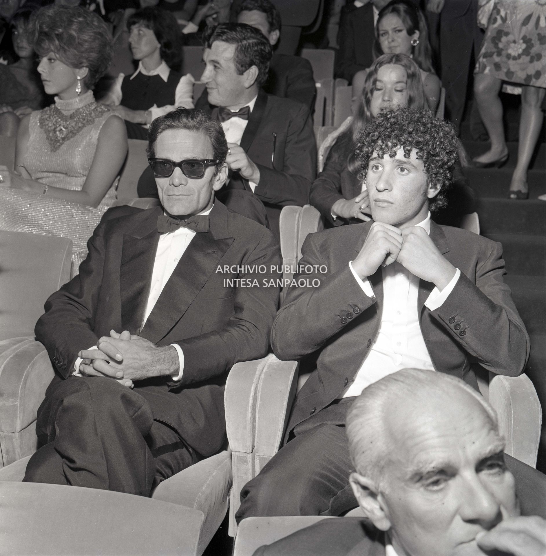 Pier Paolo Pasolini e Ninetto Davoli alla Mostra Internazionale d'arte cinematografica dove il regista presenta il film Edipo Re; in primo piano il presidente della giuria Alberto Moravia